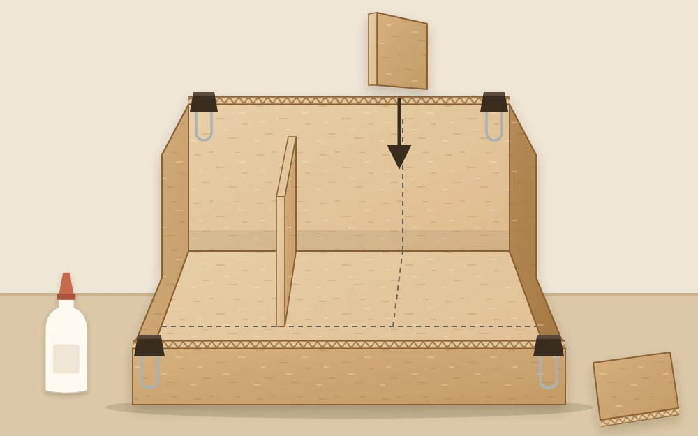 Partly assembled organizer with base and outer walls glued, dividers going in and binder clips on the corners