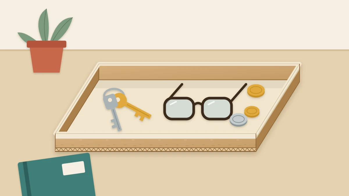Shallow rectangular cardboard tray holding a set of keys, a pair of glasses and a few coins