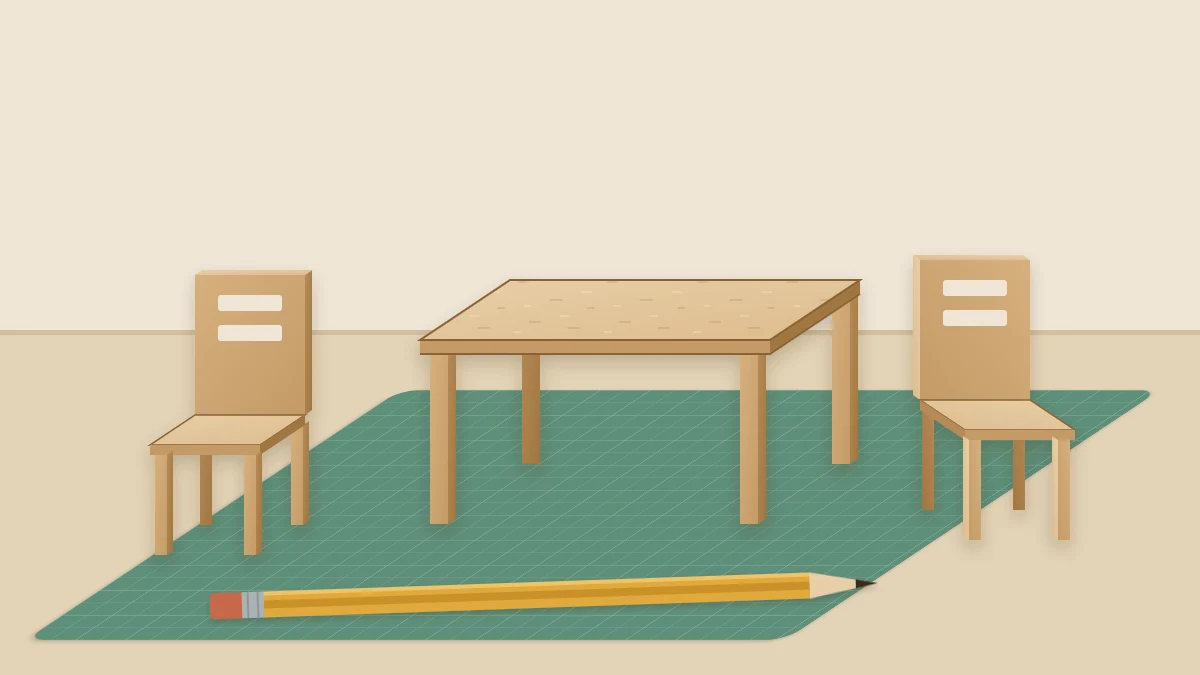 Miniature cardboard table with two tiny chairs standing on a work surface next to a pencil for scale